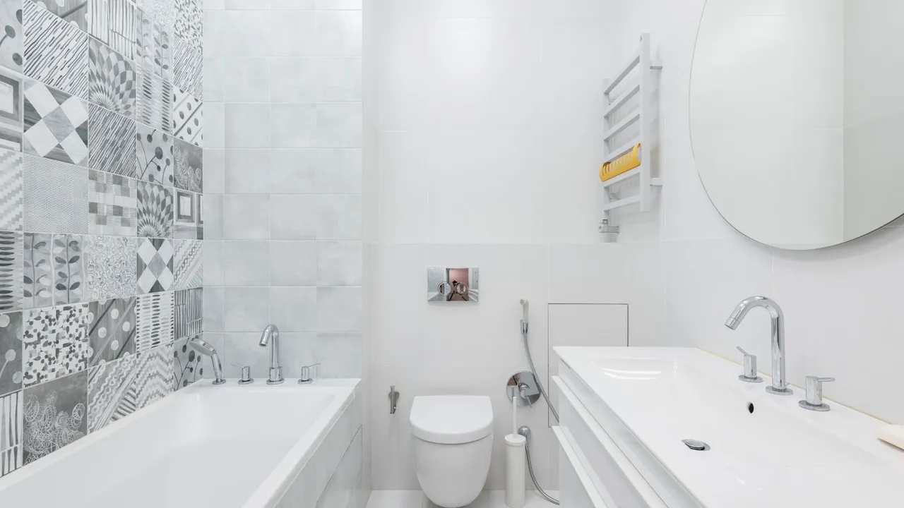 Person installing a toilet bowl over a floor flange with a wax ring