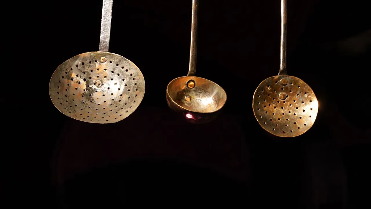 A metal sink strainer catching food scraps in a kitchen drain