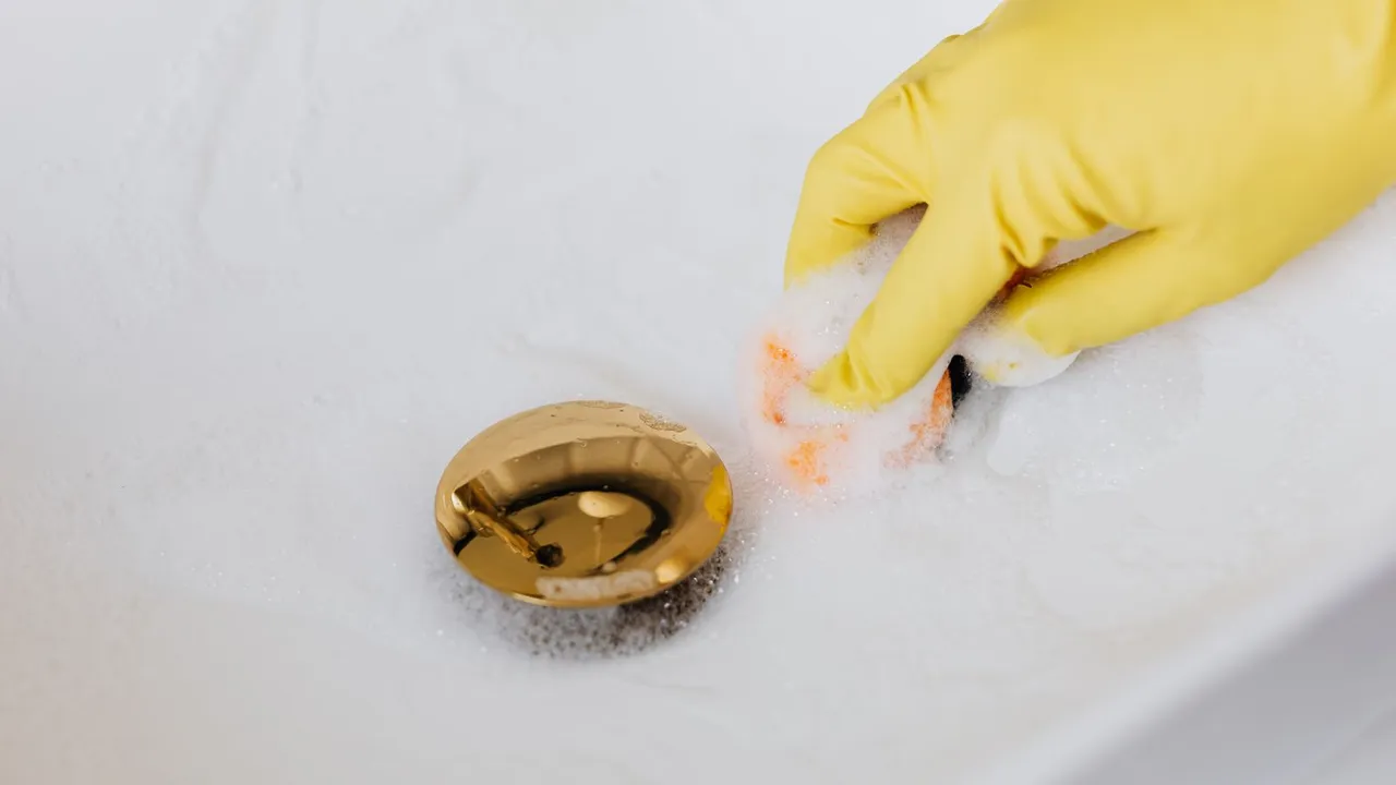 Hand drain snake being fed into a kitchen sink drain