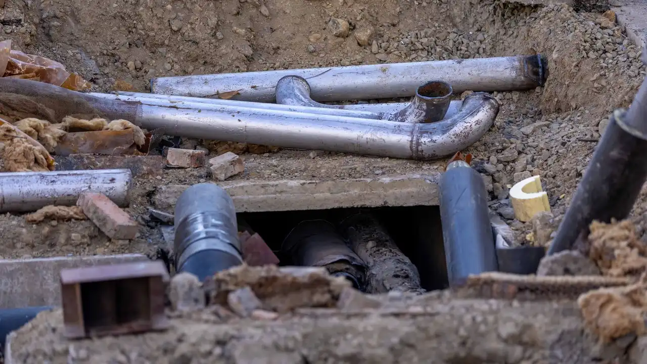 Foam-insulated water pipes running along a basement wall